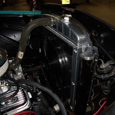 Close-up of a car radiator and engine components under the hood.