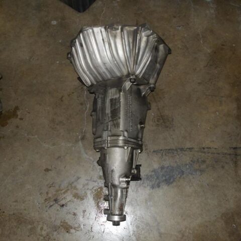 A metallic automotive transmission part on a concrete floor.
