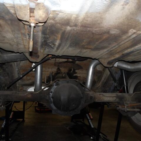 Underside view of a vehicle's rear axle and suspension system.