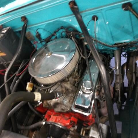 Close-up of a car engine with visible air filter and hoses.