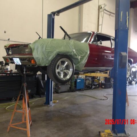 Classic car lifted in a garage for restoration work.