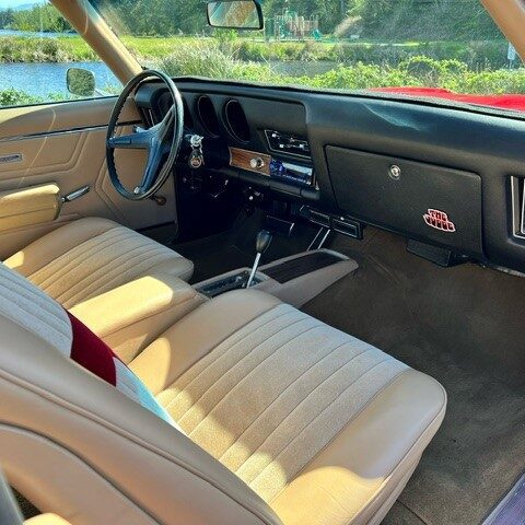Interior of a classic car with beige seats and a clean dashboard.