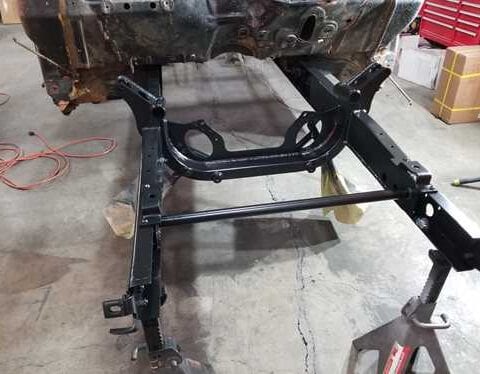 Black car subframe mounted on jackstands