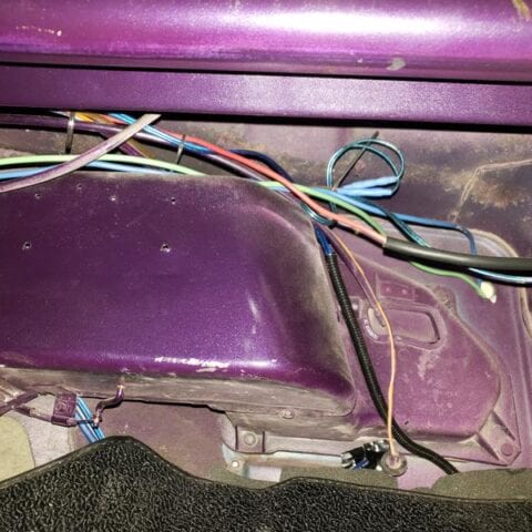 Purple car trunk interior with exposed wiring