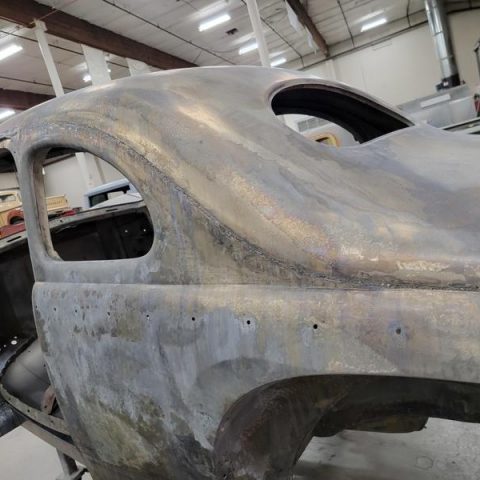 Stripped classic car body in workshop