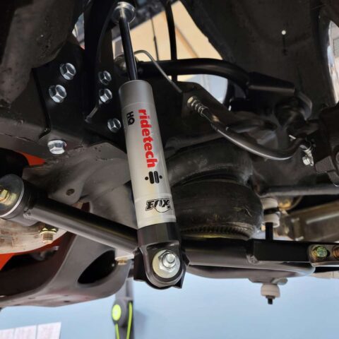 Close-up of a car's suspension component with a visible TAS shock absorber.