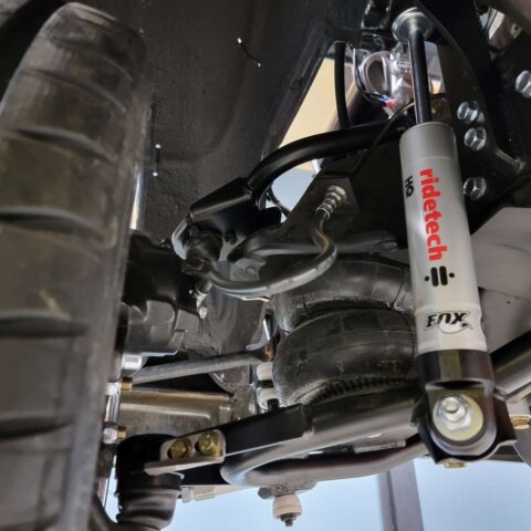 Close-up of a car's suspension system with visible shock absorber and spring.