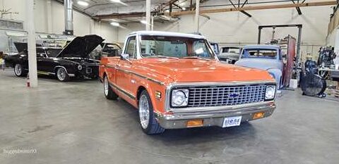 Classic orange vintage pickup truck in a garage.