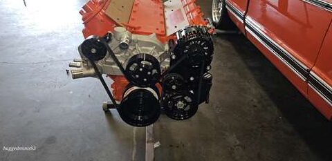 Old engine with rust and black pulleys.