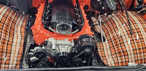 Close-up of a car engine with an orange exterior.