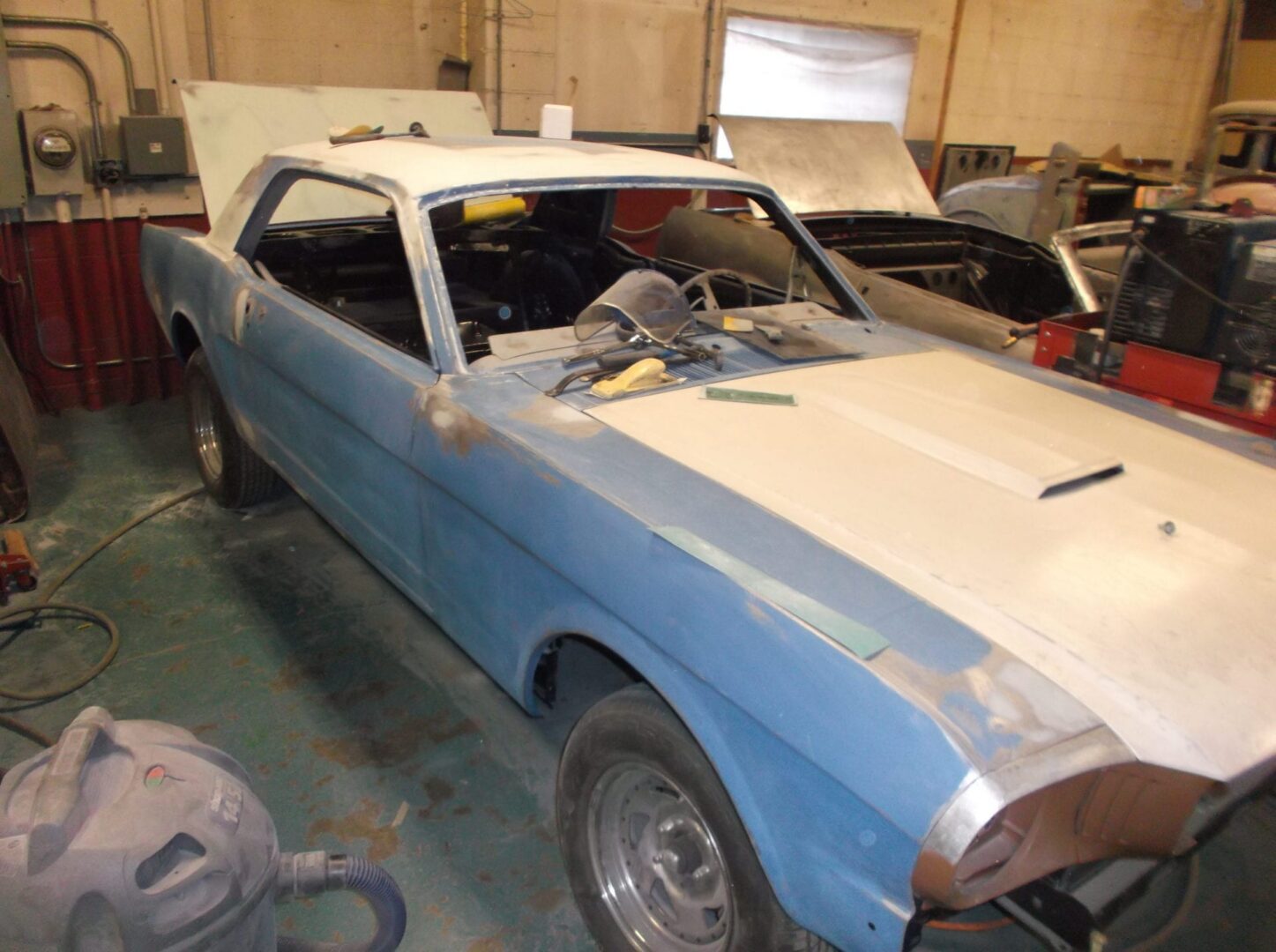 Classic car undergoing restoration in garage