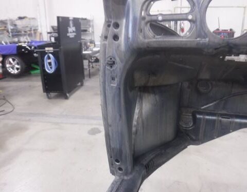 Stripped car body shell in auto workshop
