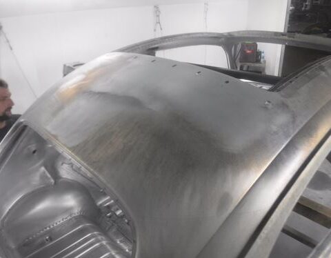 Bare metal car roof undergoing restoration