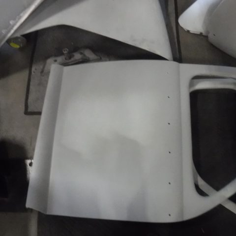 White automotive door panel on workshop floor