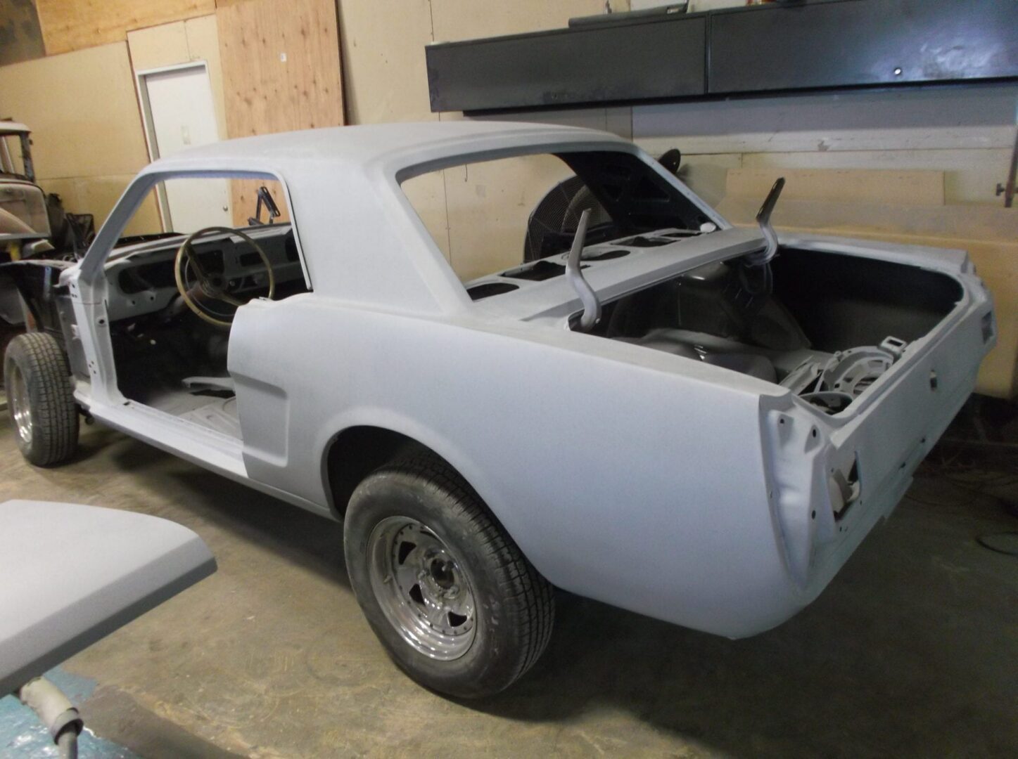 Classic car shell being restored in garage