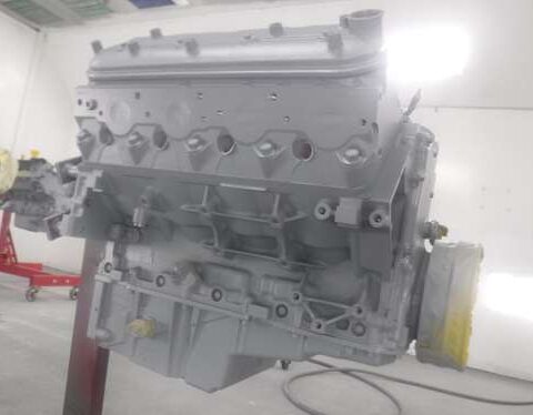 A painted engine block in a workshop setting.