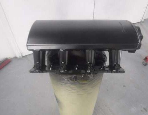 Black rectangular object on a cylindrical base with a translucent bottom.