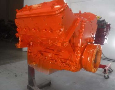 Orange-painted engine block on a stand.