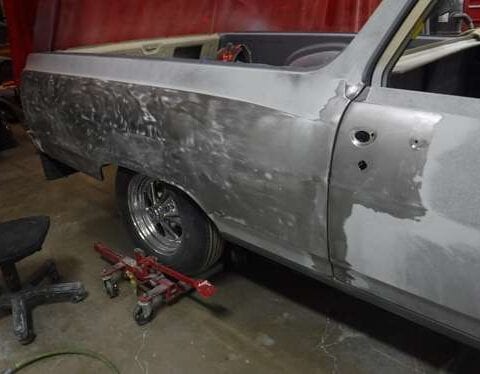 Sanded car body in workshop with wheel