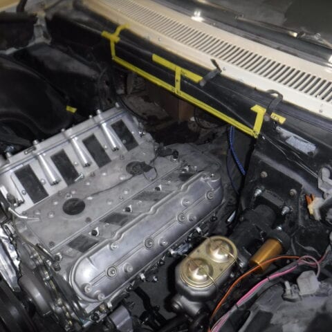Exposed aluminum car engine in open engine bay