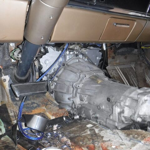 Exposed car transmission under dashboard with wiring
