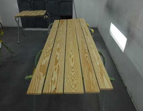 Wooden planks drying on sawhorses in workshop