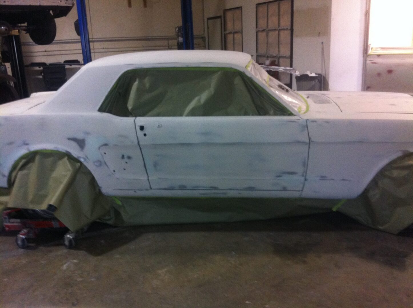 Classic car masked for painting in garage