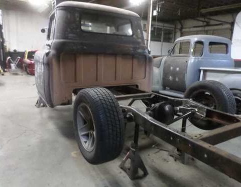Vintage pickup truck chassis undergoing restoration in garage